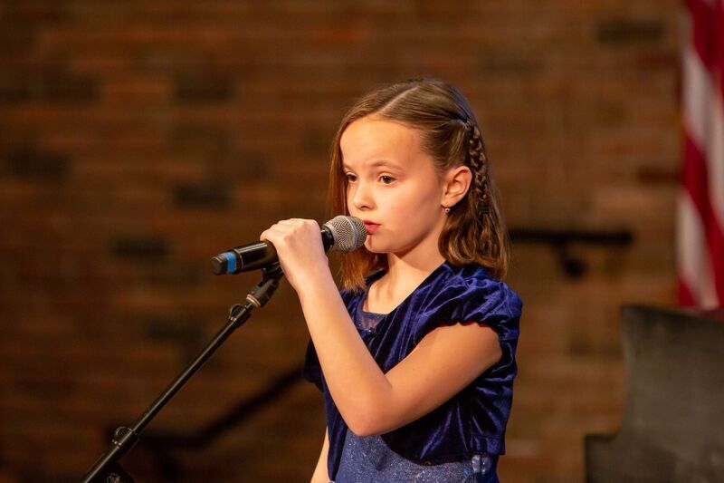 child singing on stage